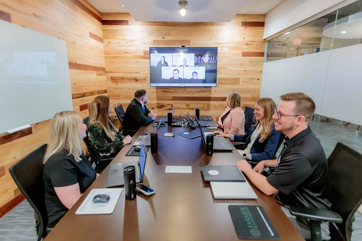 farmer cpa employees in conference room attending a virtual meeting with clients